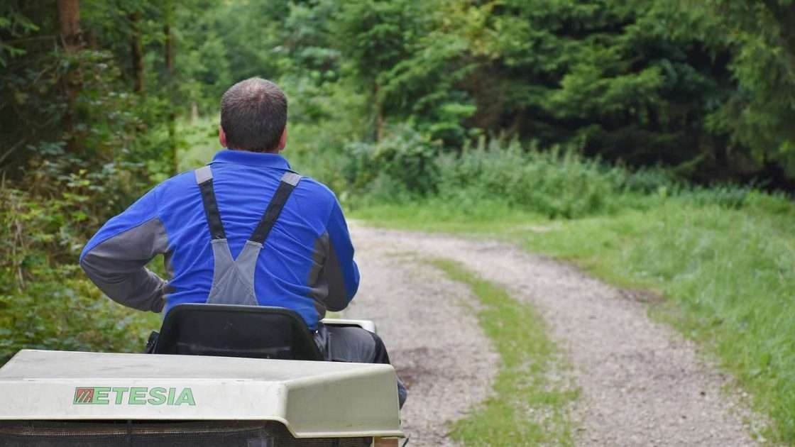 Contractor on a ride-on mower maintaining grounds, equipment funded through landscaping equipment finance