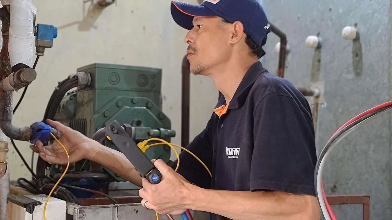 Refrigeration engineer servicing a commercial chiller, maintenance that can be bundled into a lease