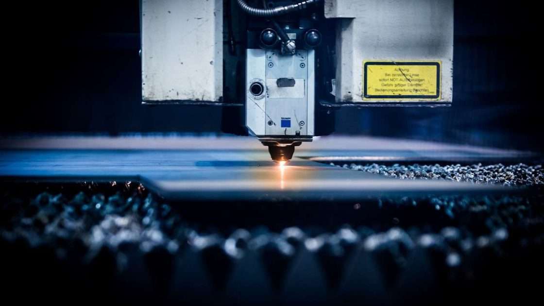 Laser cutting machine cutting steel sheet with sparks, equipment funded through laser cutting machine finance