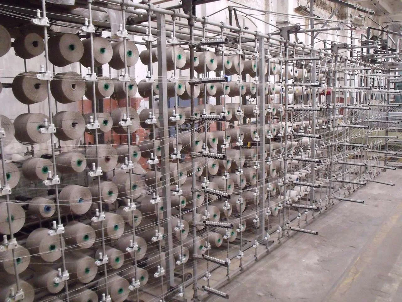 Cones of cotton yarn on a creel in a spinning and weaving mill