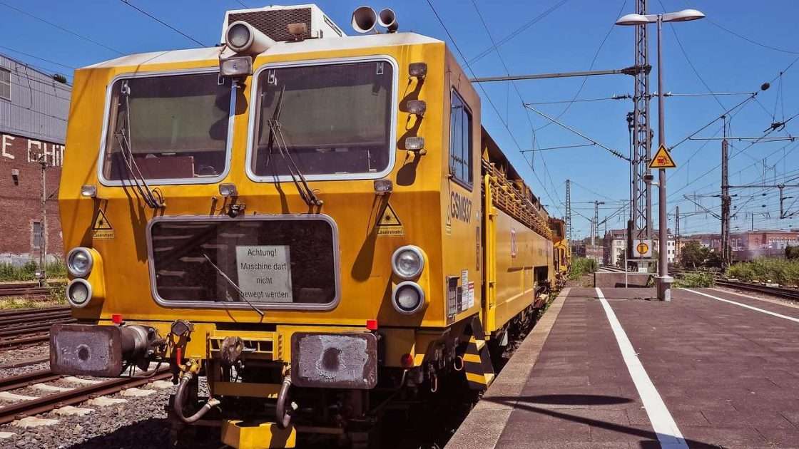 Track maintenance machine working on a railway line beside a station platform