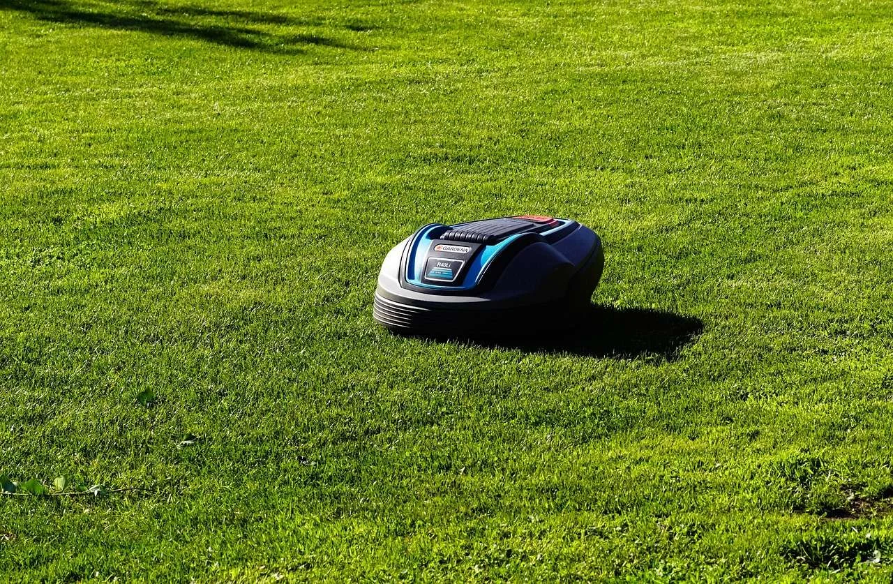 Battery-powered mower cutting a maintained lawn
