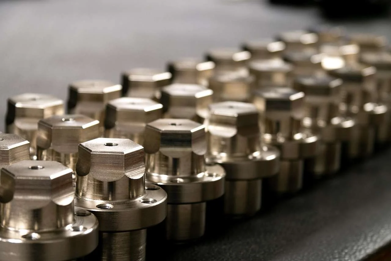 Row of precision machined metal components on a workshop bench