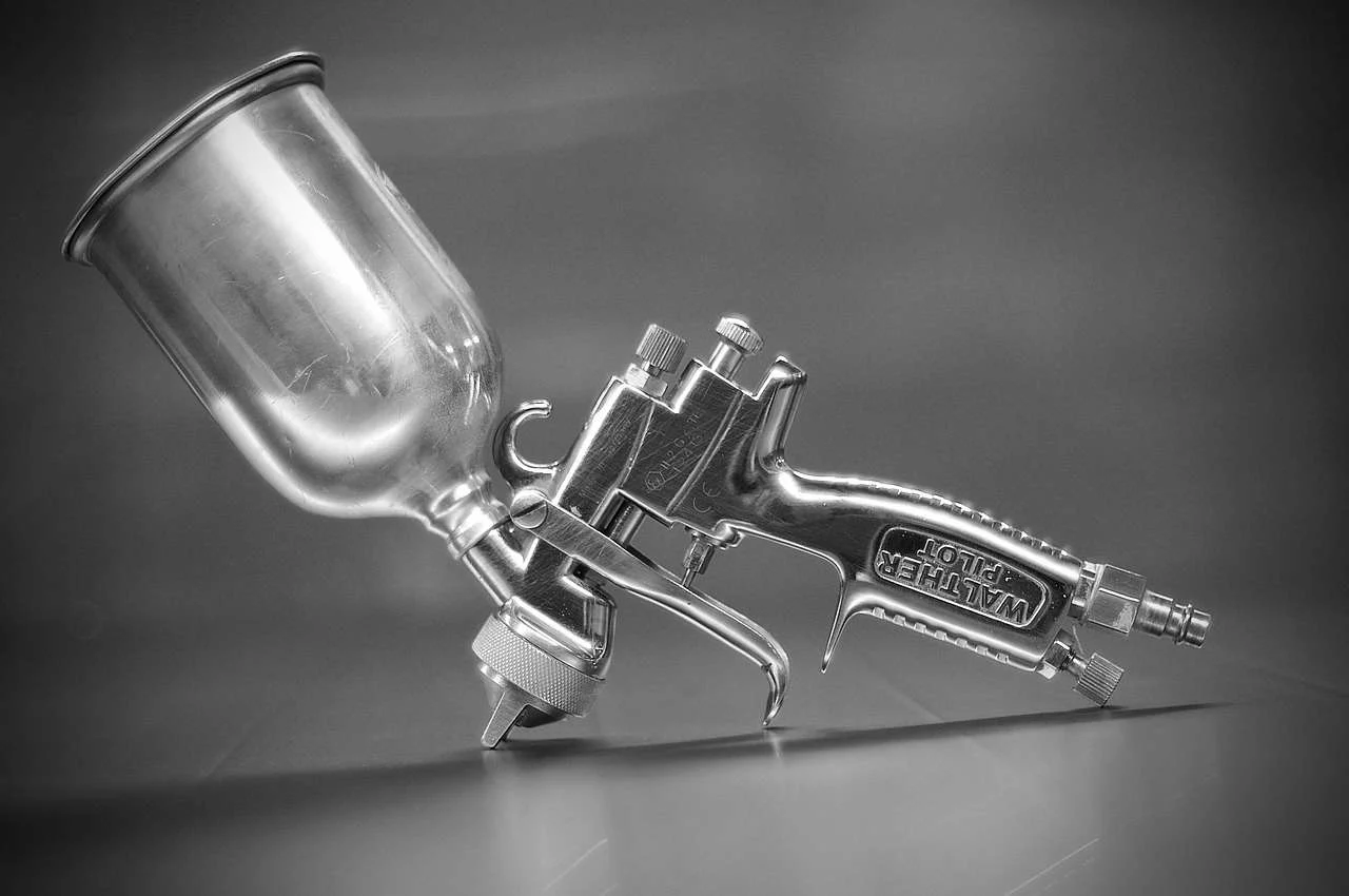 Gravity-fed spray gun used for refinishing vehicle body panels