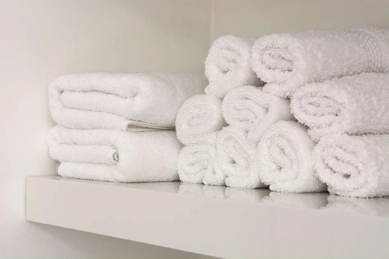 Clean towels stacked in a hotel, the kind of linen an on-premise laundry processes