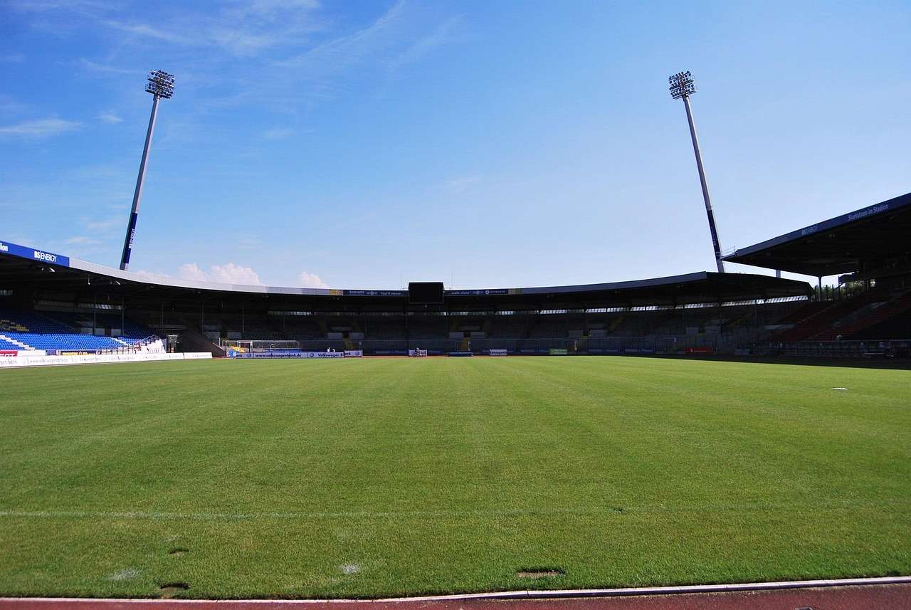 Football pitch under floodlights in a stadium