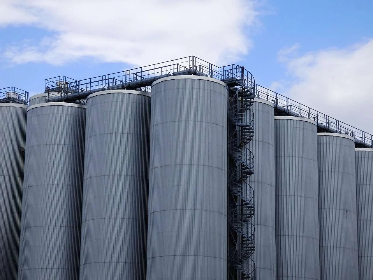 Row of large stainless steel vats in a drinks production plant