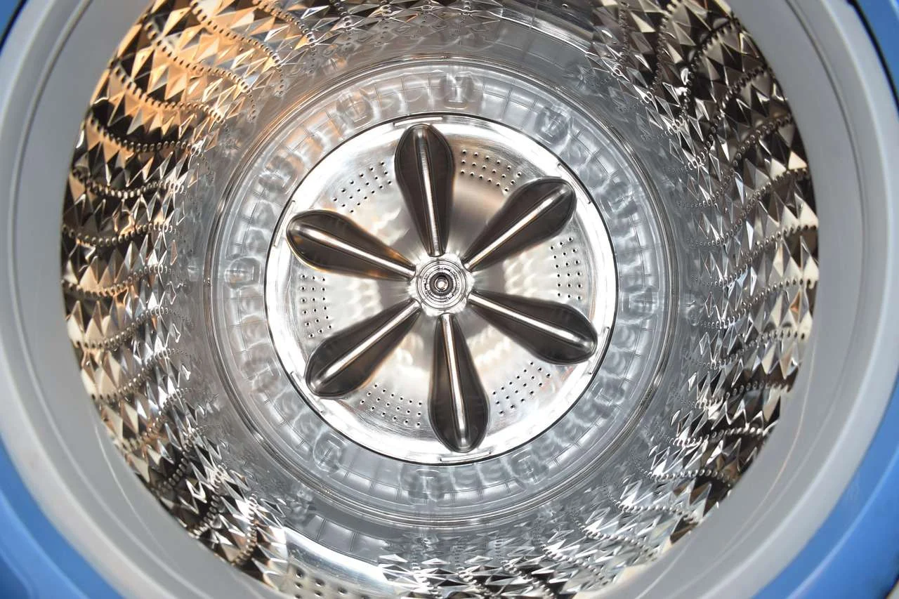 Inside the stainless steel drum of a commercial washer extractor