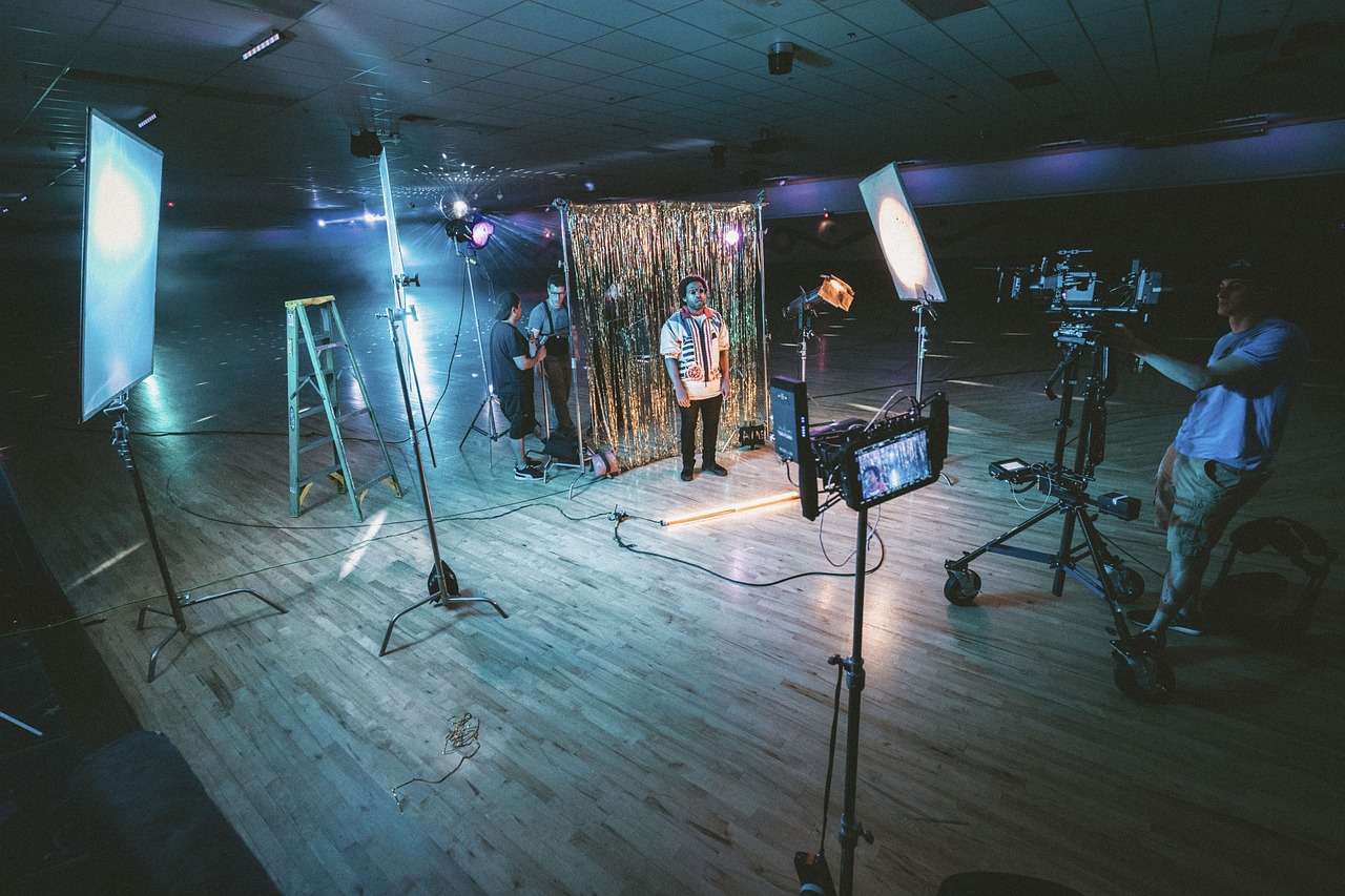 Video crew filming with professional cameras and studio lights