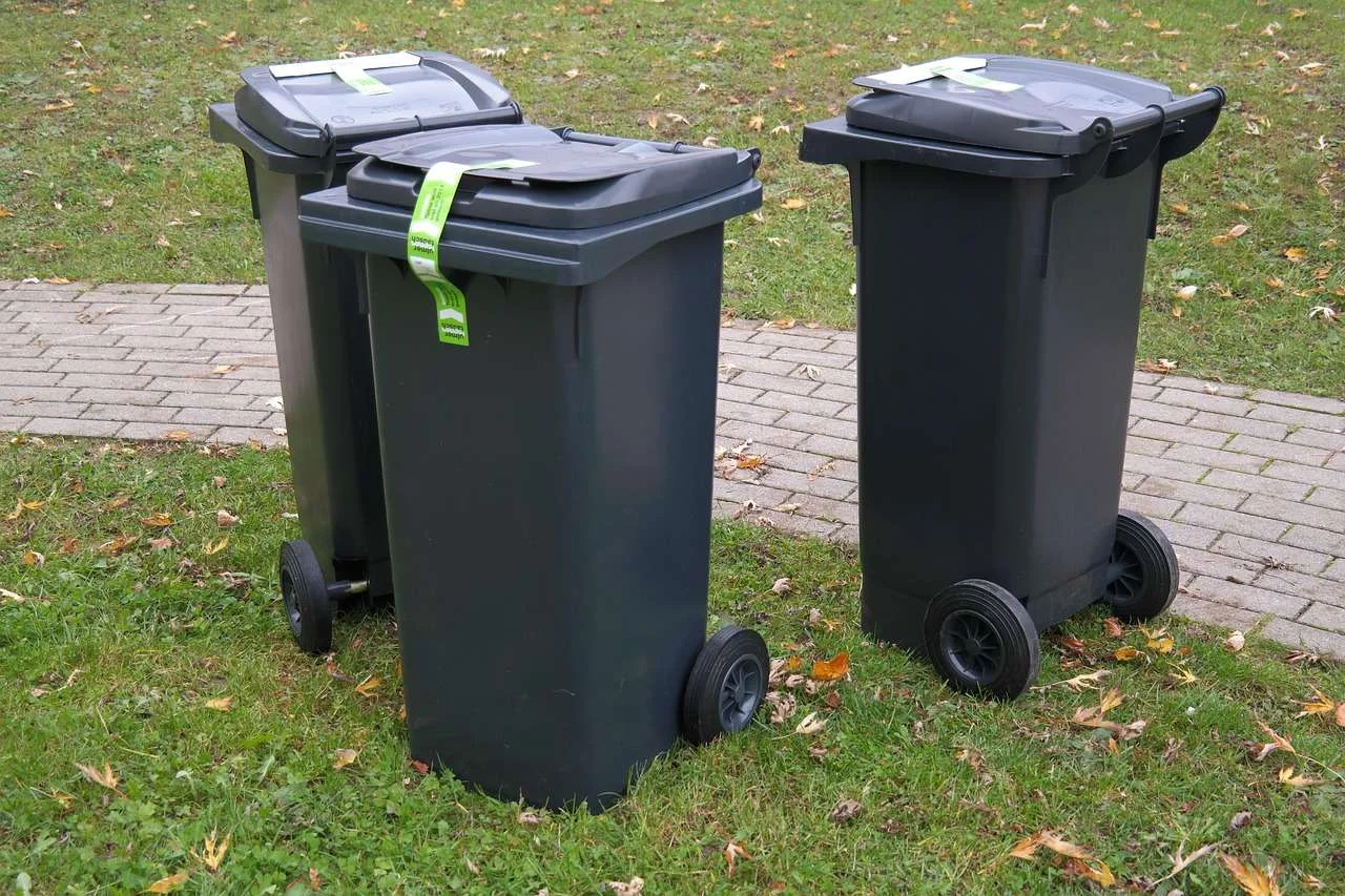 Large four-wheeled commercial waste containers lined up for collection