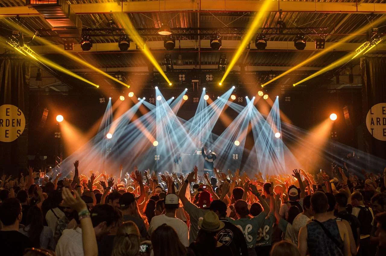 Concert crowd in front of a stage with lighting rig