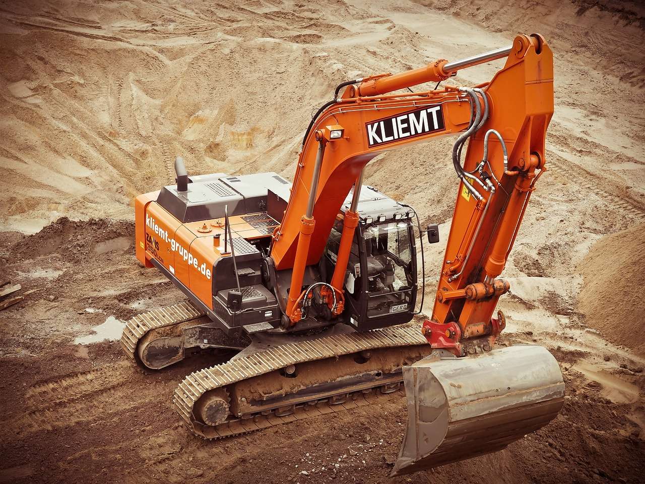 Tracked excavator digging on a construction site, the kind of machine funded through asset finance for plant hire companies