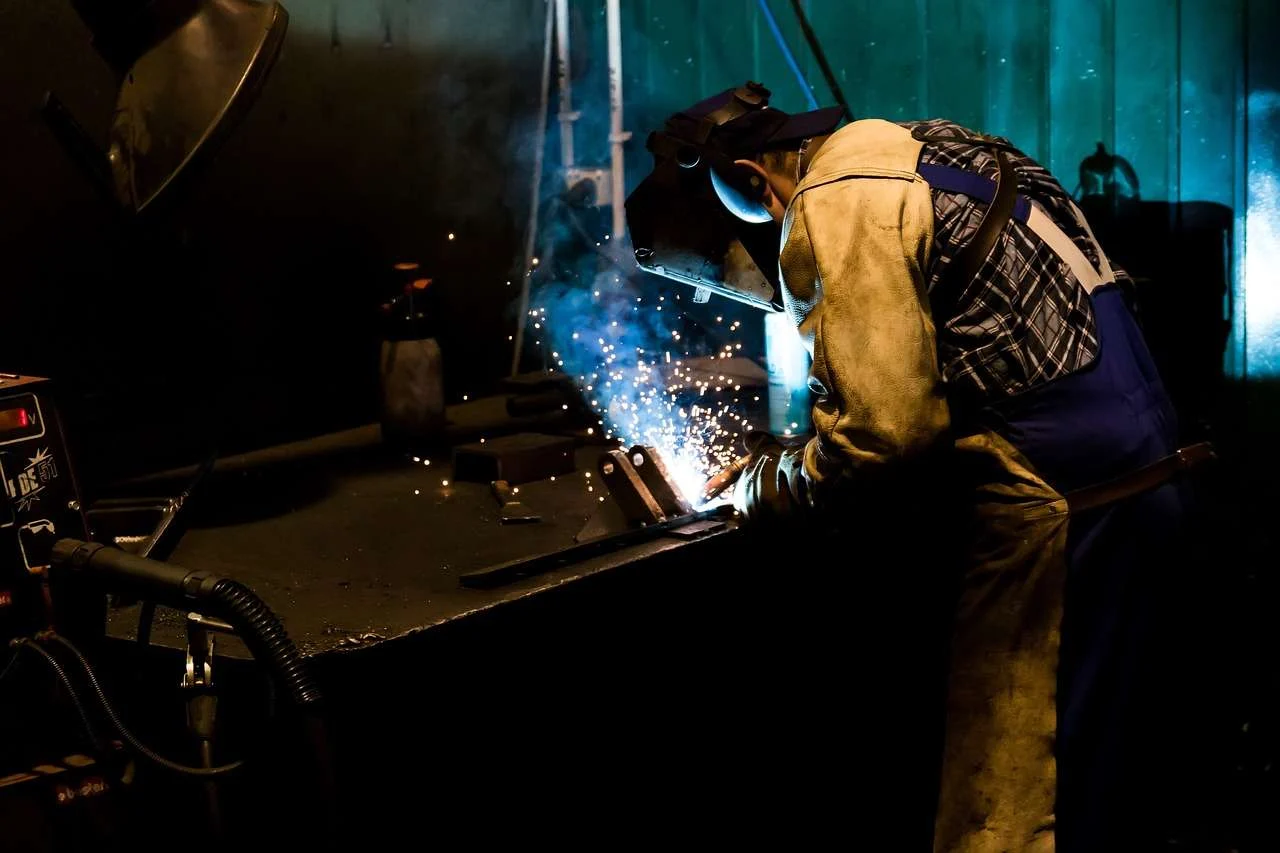Welder joining stainless steel on a factory welding bench
