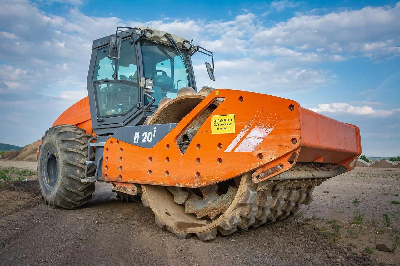 Ride-on road roller compacting a new surface, plant that hire companies fund on hire purchase