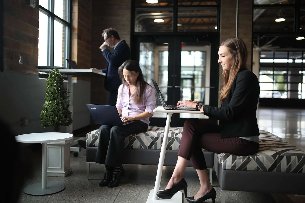 Staff working at desks with laptops and monitors in an office