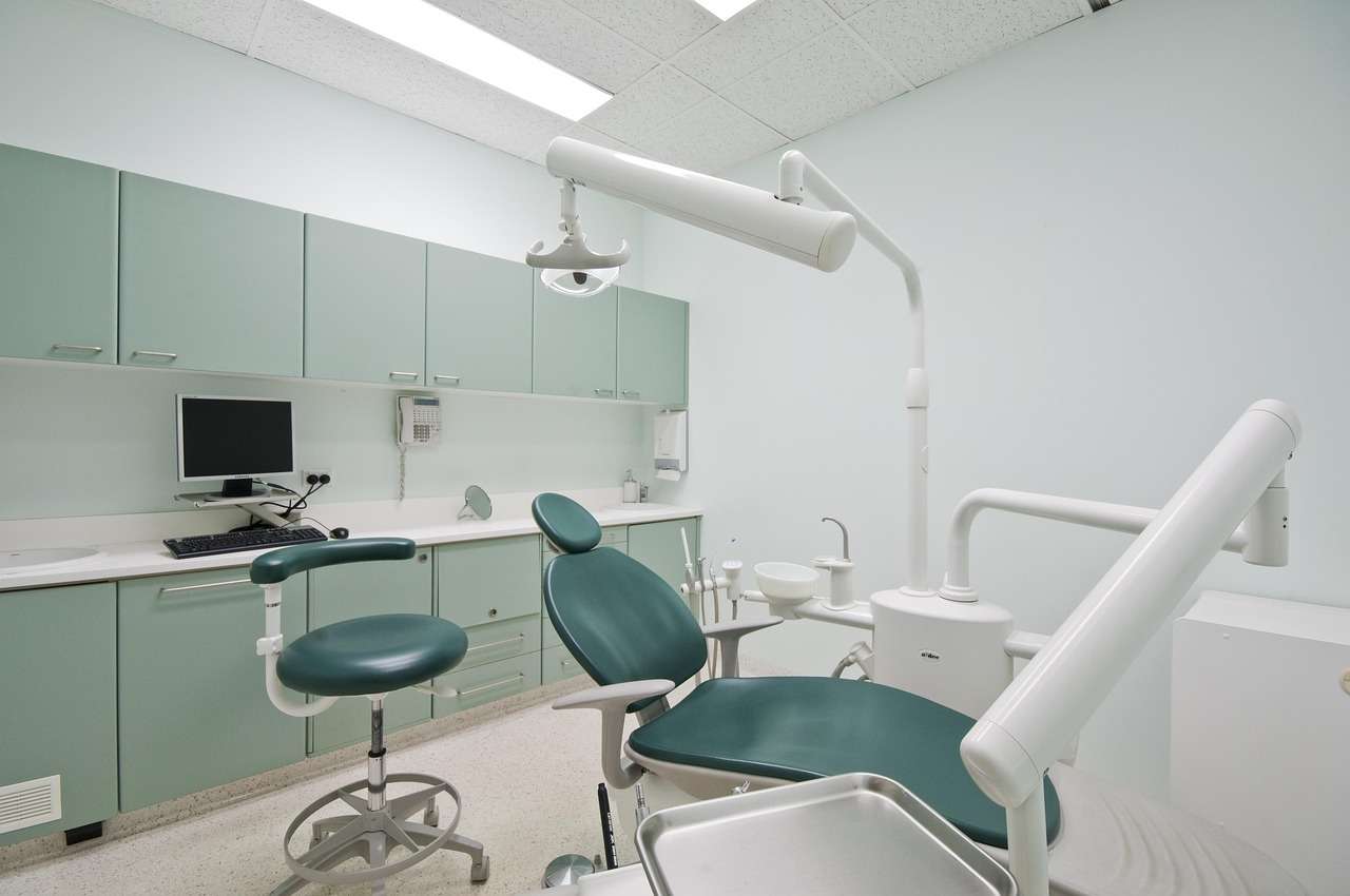 Dental surgery with patient chair, operating light and delivery unit