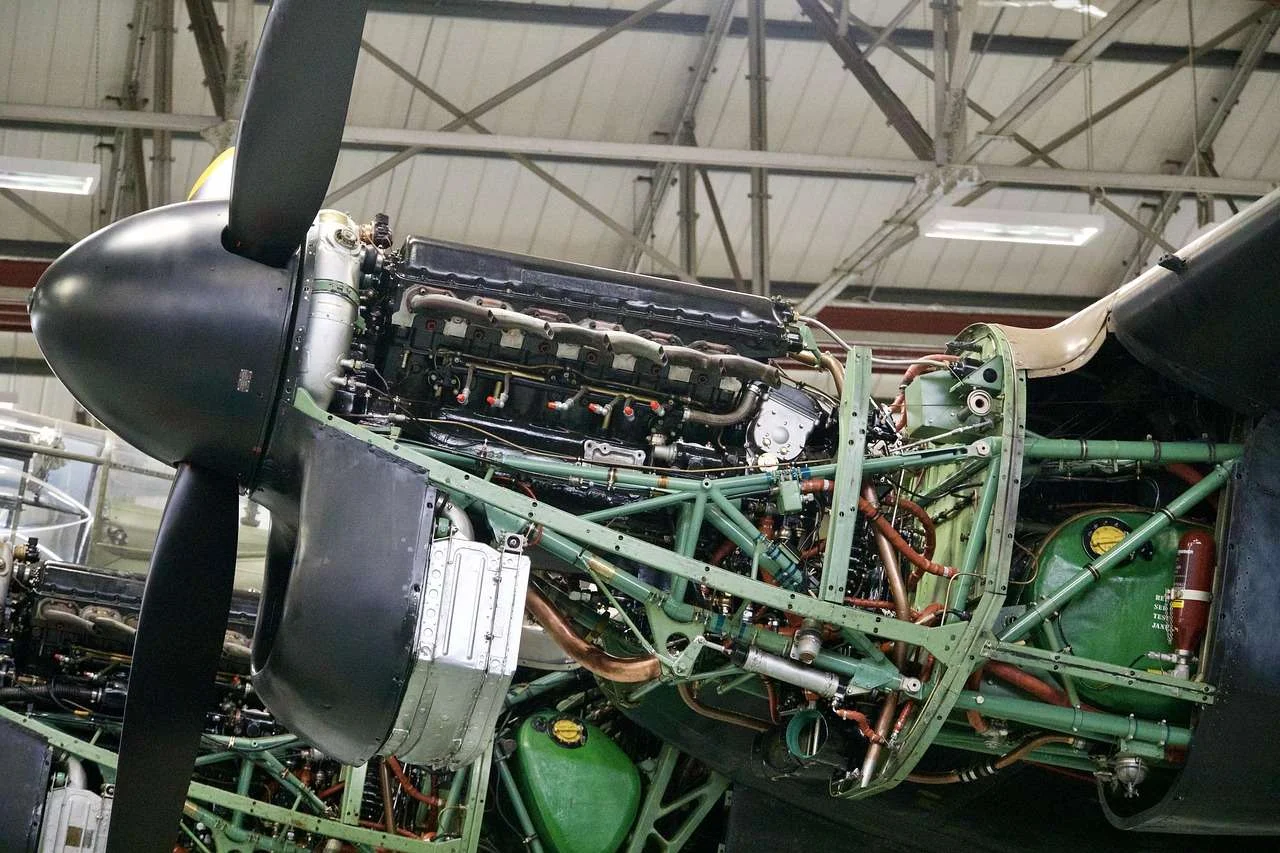 Engineer working on an aircraft engine with the cowling open during maintenance