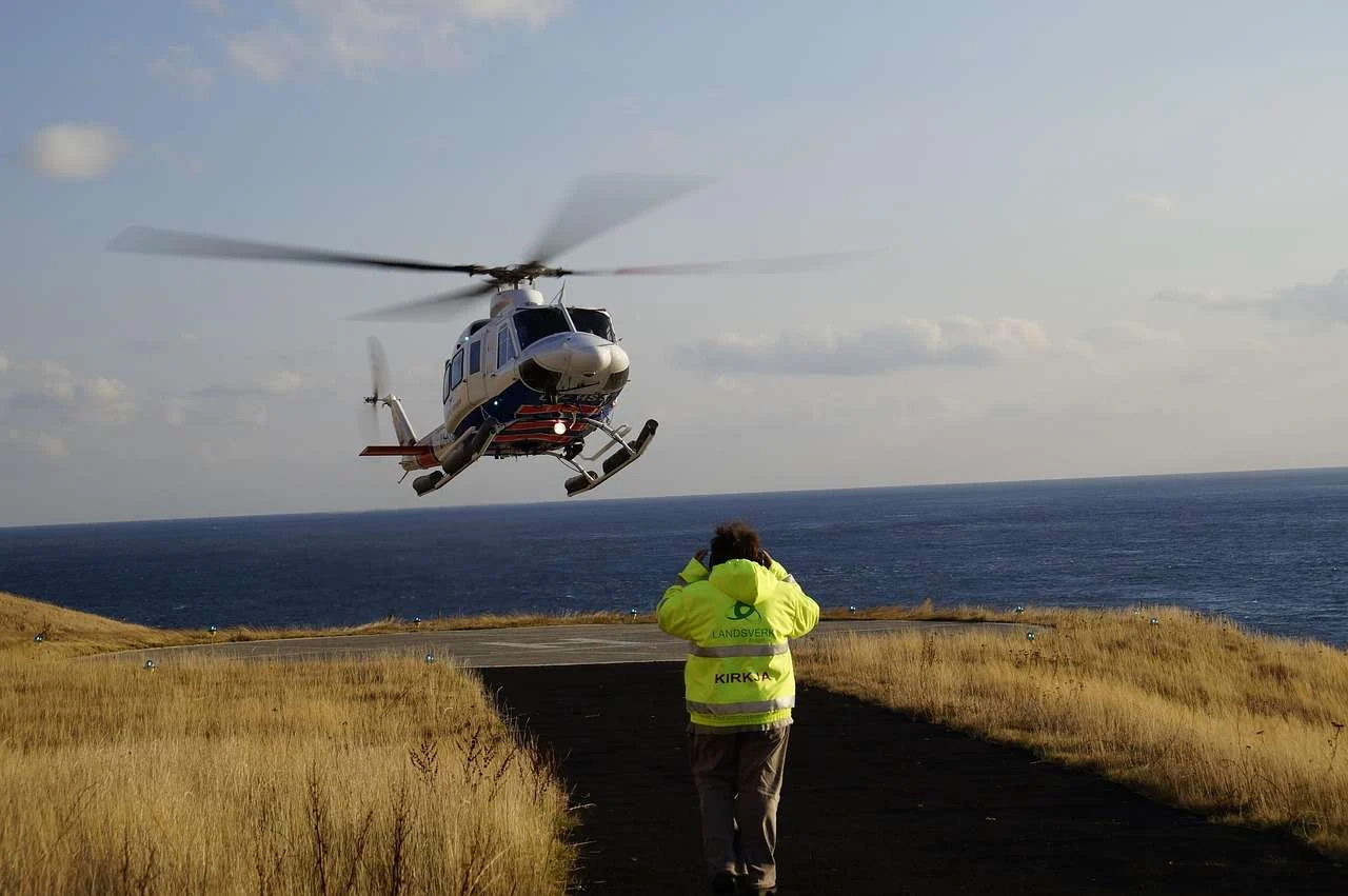 Helicopter landing on a helipad with ground staff waiting